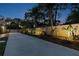 Long backyard driveway lined with landscaped shrubs and lighting at twilight at 7507 Beasley Rd, Tampa, FL 33615