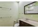 Cozy bathroom featuring a dark wood vanity, matching framed mirror, and a toilet with a shower in the background at 7507 Beasley Rd, Tampa, FL 33615