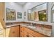 Bathroom featuring double sinks, granite countertops, and light wood cabinets at 7507 Beasley Rd, Tampa, FL 33615