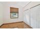 Bright bedroom with hardwood floors, double closets, and a window with a woven shade at 7507 Beasley Rd, Tampa, FL 33615