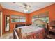 Bedroom with orange walls, ceiling fan, and two windows at 7507 Beasley Rd, Tampa, FL 33615