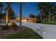 View of ranch home with an extended driveway and lush tropical landscaping at twilight at 7507 Beasley Rd, Tampa, FL 33615
