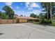 Ranch home with large driveway, mature trees, and fenced yard on a sunny day at 7507 Beasley Rd, Tampa, FL 33615
