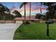 Charming single-story home with a manicured lawn and palm trees under a colorful sunset sky at 7507 Beasley Rd, Tampa, FL 33615