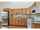 Cozy kitchen features oak cabinets, stainless steel refrigerator, and white appliances at 7507 Beasley Rd, Tampa, FL 33615