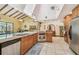 Bright kitchen with island cooktop, tile floor, wood cabinets, granite counters, with natural light from skylight at 7507 Beasley Rd, Tampa, FL 33615