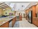 Open kitchen featuring light wood cabinetry, granite counters, and an island cooktop, with a view to the sitting area at 7507 Beasley Rd, Tampa, FL 33615