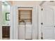 Convenient laundry room with washer, dryer, and shelving for storage at 7507 Beasley Rd, Tampa, FL 33615