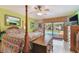 Main bedroom offering ceiling fan, four poster bed, wood floors, dresser, and access to a pool view at 7507 Beasley Rd, Tampa, FL 33615