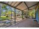 Screened patio featuring a brick floor, lush landscaping views, and a cool ceiling fan at 7507 Beasley Rd, Tampa, FL 33615