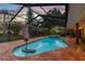 Stunning screened-in pool area with brick patio and lush landscaping for ultimate relaxation and entertainment at 7507 Beasley Rd, Tampa, FL 33615