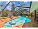 Screened pool with a built-in spa, umbrella, and brick tile in a sunny backyard at 7507 Beasley Rd, Tampa, FL 33615