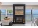 Cozy living room with a fireplace, comfortable seating, and serene water views through shuttered windows at 7520 Sunshine Skyway S Ln # 109, St Petersburg, FL 33711