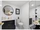 Stylish powder room with modern fixtures, a round mirror, and ample lighting at 7520 Sunshine Skyway S Ln # 109, St Petersburg, FL 33711