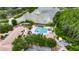 Aerial view of the pool, tennis courts and clubhouse with a relaxing fountain and scenic trees in the background at 9481 Highland Oak Dr # 1511, Tampa, FL 33647