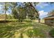 Expansive backyard with lush green lawn, trees, and a glimpse of the house at 9542 Wallien Dr, Brooksville, FL 34601