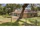 Backyard with fenced yard and patio area with mature trees providing shade at 9542 Wallien Dr, Brooksville, FL 34601