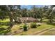 Backyard featuring a hammock, brick accents, mature trees, and lush grass at 9542 Wallien Dr, Brooksville, FL 34601