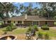 Backyard boasts a fire pit, lush garden, and seating near the house at 9542 Wallien Dr, Brooksville, FL 34601