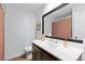 Clean bathroom with white sink, dark wood cabinets, and framed mirror at 9542 Wallien Dr, Brooksville, FL 34601