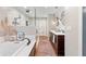 Bright bathroom featuring dual sinks, soaking tub, walk-in shower, and dark wood cabinets at 9542 Wallien Dr, Brooksville, FL 34601