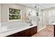 Relaxing bathroom with a soaking tub, dark wood cabinets, and a window with beautiful views at 9542 Wallien Dr, Brooksville, FL 34601
