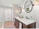 Double sink bathroom vanity with white countertop, wood cabinets and round mirrors at 9542 Wallien Dr, Brooksville, FL 34601