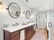 Bathroom featuring double sinks with dark wood cabinets, white countertops, and modern fixtures at 9542 Wallien Dr, Brooksville, FL 34601