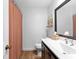 Bathroom with white sink, dark wood cabinets, framed mirror, and bathtub at 9542 Wallien Dr, Brooksville, FL 34601