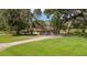 Landscaped brick home exterior surrounded by mature shade trees and sprawling lawn at 9542 Wallien Dr, Brooksville, FL 34601