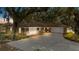 Beautiful exterior of a brick home featuring a manicured lawn and a long driveway leading to an attached garage at 9542 Wallien Dr, Brooksville, FL 34601