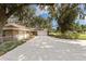 Charming exterior view of a home with a well-kept lawn, long driveway, and a partially shaded front yard at 9542 Wallien Dr, Brooksville, FL 34601