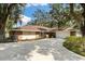 Brick home with large driveway surrounded by mature shade trees at 9542 Wallien Dr, Brooksville, FL 34601