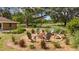 Brick fire pit with Adirondack chairs, set amidst a backyard landscape at 9542 Wallien Dr, Brooksville, FL 34601
