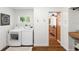 Bright laundry room with modern washer and dryer, window, and decorative wreath at 9542 Wallien Dr, Brooksville, FL 34601