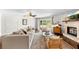 Bright living room with decorative fireplace, neutral furniture, hardwood floors, and a view to the outdoors at 9542 Wallien Dr, Brooksville, FL 34601