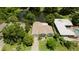 Aerial view of a home with a beautiful lake view, lush landscaping, and a pool at 3010 Grand View Ave, Clearwater, FL 33759