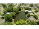 Aerial view of a neighborhood with houses surrounding a pond, highlighting a peaceful community at 3010 Grand View Ave, Clearwater, FL 33759