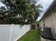 Backyard featuring a white fence, a large mango tree, a shed, and air conditioning unit at 3010 Grand View Ave, Clearwater, FL 33759