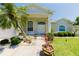 Inviting home featuring a manicured lawn, lush landscaping, and a decorative double-door entrance at 3010 Grand View Ave, Clearwater, FL 33759
