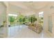 Sunroom with tile flooring and large windows offering views of the pond at 3010 Grand View Ave, Clearwater, FL 33759