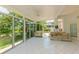 Light-filled sunroom with tile flooring and views of the surrounding landscaping and pond at 3010 Grand View Ave, Clearwater, FL 33759