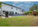 Large backyard featuring a pool with safety fence, green grass, and outdoor seating at 4111 W Swann Ave, Tampa, FL 33609