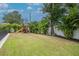 Spacious backyard featuring a playset surrounded by lush green lawn and landscaping at 4111 W Swann Ave, Tampa, FL 33609
