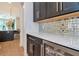 Wet bar featuring black cabinets, wine fridge, and a countertop with a mirrored backsplash at 4111 W Swann Ave, Tampa, FL 33609