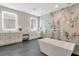 Modern bathroom featuring dual vanities, a soaking tub, and a glass-enclosed shower with tile accent wall at 4111 W Swann Ave, Tampa, FL 33609