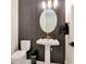Chic powder room features black accent wall with textured tiles and gold hardware at 4111 W Swann Ave, Tampa, FL 33609