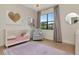Cozy bedroom featuring light hardwood floors, plush area rug, and a well-lit window offering picturesque views at 4111 W Swann Ave, Tampa, FL 33609