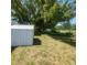 Secluded backyard featuring shade trees, storage shed and grassy area at 10031 Cherry Creek Ln, Port Richey, FL 34668