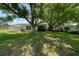 Spacious backyard with large trees, green lawn and a screened in porch at 10031 Cherry Creek Ln, Port Richey, FL 34668